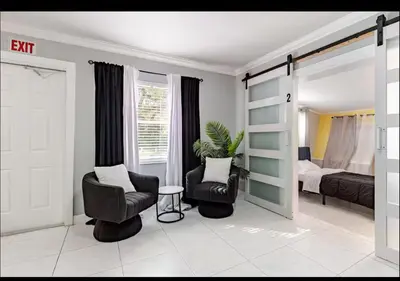 a living room with two chairs and a bed at Homeaway Haven in Fort Lauderdale