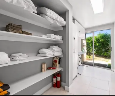a laundry room with white shelves and a window at Homeaway Haven in Fort Lauderdale