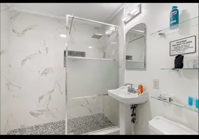 a white bathroom with a shower and a sink at Homeaway Haven in Fort Lauderdale