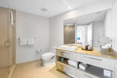 a bathroom with a sink and a toilet and a mirror at Oceanfront Retreat Steps from Hollywood Beach in Hollywood