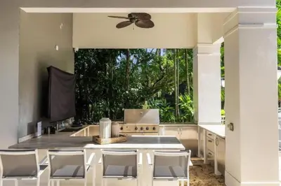 a kitchen with white chairs and a ceiling fan at New Luxe Super Villa by The Glam Homes in Plantation