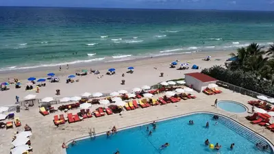 an overhead view of a beach with people and umbrellas at Sunny Isles Oceanfront Apartment for Two in Sunny Isles Beach