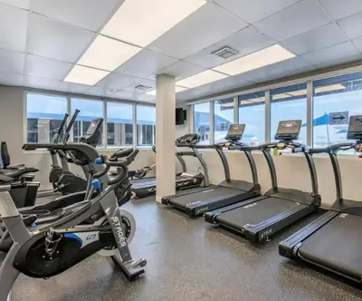 a gym with treadmills and elliptical machines at Sunny Isles Oceanfront Apartment for Two in Sunny Isles Beach