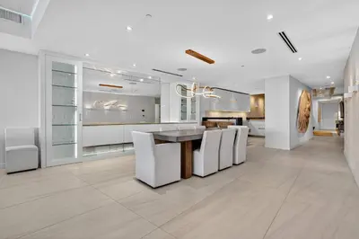 a white kitchen with a table and white chairs at Auberge Blue by Rove Travel Oceanfront with Balcony in Fort Lauderdale