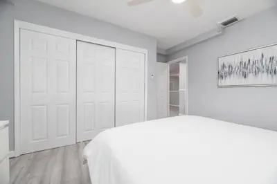 a white bedroom with a bed and a large closet at The Residences at Lake Ridge Apt 1 in Fort Lauderdale