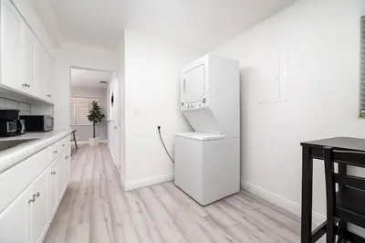 a white kitchen with a refrigerator with a mirror at The Residences at Lake Ridge Apt 1 in Fort Lauderdale