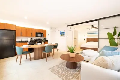 a living room and kitchen with a couch and a table at SOFI NEW! King Bed, Beach, BBQ, Gated! in Miami Beach