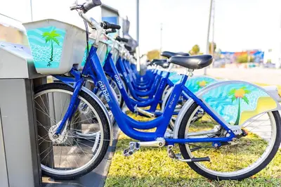a row of blue bikes parked next to a wall at SOFI NEW! King Bed, Beach, BBQ, Gated! in Miami Beach