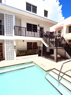 a villa with a swimming pool and a building at SOFI NEW! King Bed, Beach, BBQ, Gated! in Miami Beach