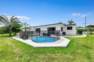 a house with a swimming pool in a yard at Trendy Waterfront Pool Home Beach Casino Airport in Hollywood