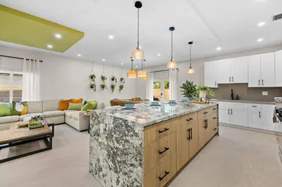 an open kitchen and living room with a large island at Luxury 4BR Retreat | Pool • Kitchen in Goulds