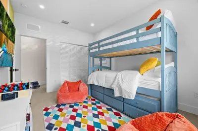 a bedroom with a blue bunk bed and a chair at Luxury 4BR Retreat | Pool • Kitchen in Goulds