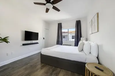 a bedroom with a large bed with a ceiling fan at The Donovan in Miami Beach