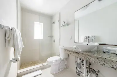 a white bathroom with a sink and a toilet at The Donovan in Miami Beach