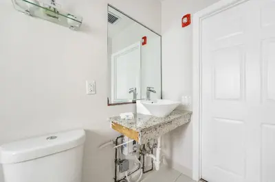a white bathroom with a sink and a toilet at The Donovan in Miami Beach
