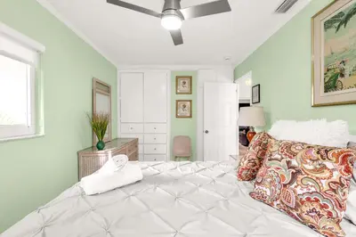 a bedroom with a white bed with a white towel on it at Backyard Oasis 3 Hole Golf Pool Fire Pit in Fort Lauderdale