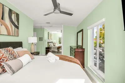 a bedroom with a bed and a window at Backyard Oasis 3 Hole Golf Pool Fire Pit in Fort Lauderdale