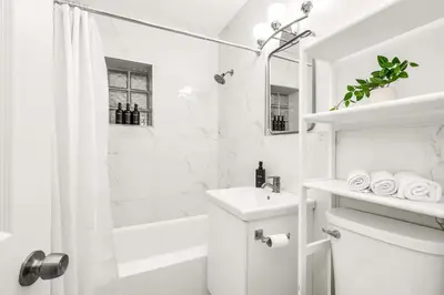 a white bathroom with a sink and a shower at Backyard Oasis 3 Hole Golf Pool Fire Pit in Fort Lauderdale