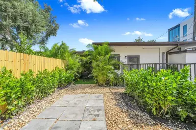 a home with a fence and a yard at Chic Modern Studio with Queen Bed in Fort Lauderdale
