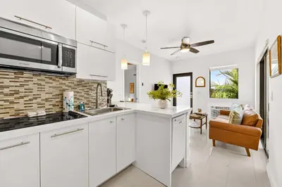 a kitchen with white cabinets and a ceiling fan at Chic Modern Studio with Queen Bed in Fort Lauderdale