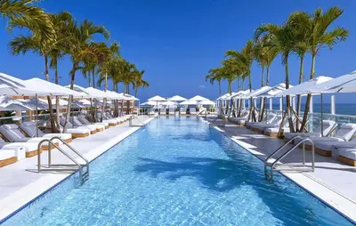 a swimming pool with lounge chairs and palm trees at Amazing View 1 Hotel Corner Unit 2BR/2BA w Balcony in Miami Beach