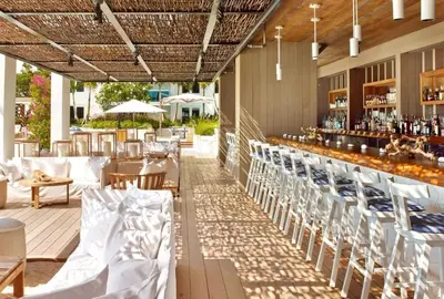 an outdoor patio with tables and chairs and a bar at Amazing View 1 Hotel Corner Unit 2BR/2BA w Balcony in Miami Beach