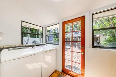 a washing machine in a laundry room with windows at Walk to Las Olas! Old Florida Oasis with Hot Tub in Fort Lauderdale
