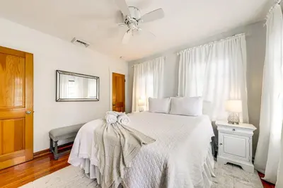 a bedroom with a white bed and a ceiling fan at Walk to Las Olas! Old Florida Oasis with Hot Tub in Fort Lauderdale