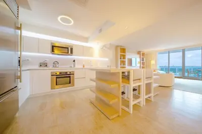 a large kitchen with white cabinets and a large window at Amazing View 1 Hotel Corner Unit 1BR/1BA w Balcony in Miami Beach