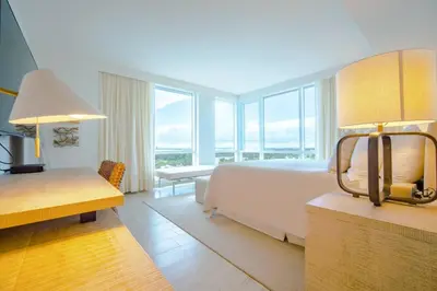 a hotel room with a bed and a large window at Amazing View 1 Hotel Corner Unit 1BR/1BA w Balcony in Miami Beach