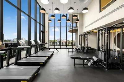 a gym with rows of tread machines and large windows at Condo at 72 Park - Miami Beach Area & Resort Facilities in Miami Beach