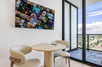 a table and two chairs in a room with windows at Resort & Beach - The Ideal Condo at 72 Park in Miami Beach