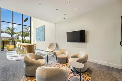 a living room with chairs and a flat screen tv at Resort & Beach - The Ideal Condo at 72 Park in Miami Beach