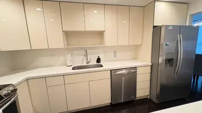 a kitchen with white cabinets and a stainless steel refrigerator at Beachfront 2BR at The Tides | EPIC Stay in Hollywood
