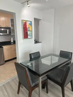 a glass dining room table with two chairs and a kitchen at Ocean Breeze Condo - Intracostal and Ocean views at GalleryOne in Fort Lauderdale