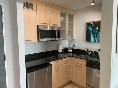 a kitchen with wooden cabinets and stainless steel appliances at Ocean Breeze Condo - Intracostal and Ocean views at GalleryOne in Fort Lauderdale