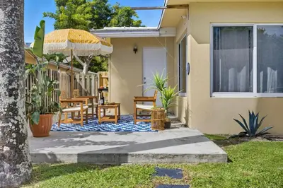 a patio with a table and chairs and an umbrella at Positano Ville I Waterfront and Grill I 10 min Beach in Fort Lauderdale