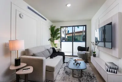 a living room with a couch and a tv at The Avenue Hotel Coral Gables in Miami