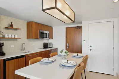 a kitchen with a white table with chairs and a sink at Skyline View Private Residence at Carillon Resort - 705 in Miami Beach