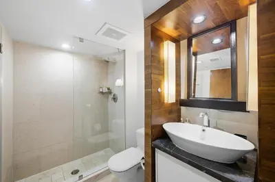 a bathroom with a sink and a toilet and a mirror at Skyline View Private Residence at Carillon Resort - 705 in Miami Beach