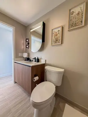a bathroom with a toilet and a sink and a mirror at Luxury View-Walk to beach! in Miami Beach
