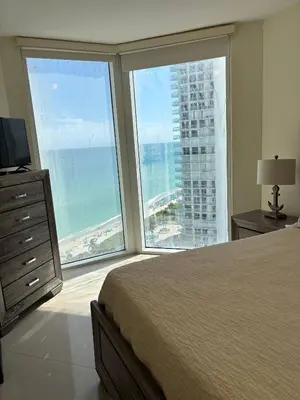 a bedroom with a bed and a view of the ocean at Luxurious 2BD Condo with Direct Ocean Views & Resort Pool in Sunny Isles in Sunny Isles Beach