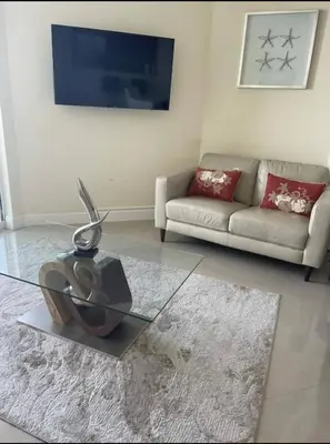 a living room with a glass table and a couch at Luxurious 2BD Condo with Direct Ocean Views & Resort Pool in Sunny Isles in Sunny Isles Beach