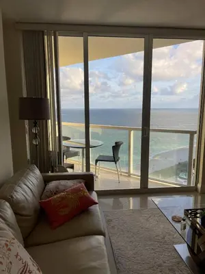 a living room with a couch and a view of the ocean at Luxurious 2BD Condo with Direct Ocean Views & Resort Pool in Sunny Isles in Sunny Isles Beach