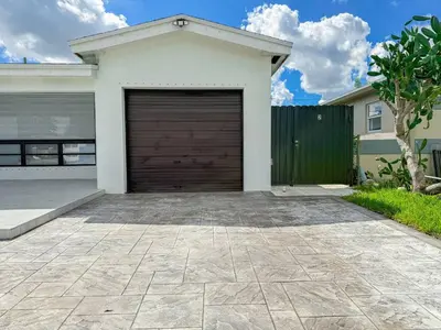 a garage door in a white house at Luxury Suite Studio with Kitchen & Spa Shower in Miramar