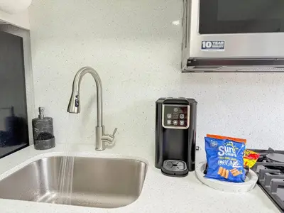 a kitchen counter top with a sink and a kitchen sink at Luxury Suite Studio with Kitchen & Spa Shower in Miramar