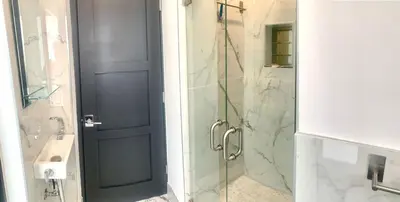 a bathroom with a shower and a glass door at MIAMi MID-CENTURY GEM in North Miami Beach
