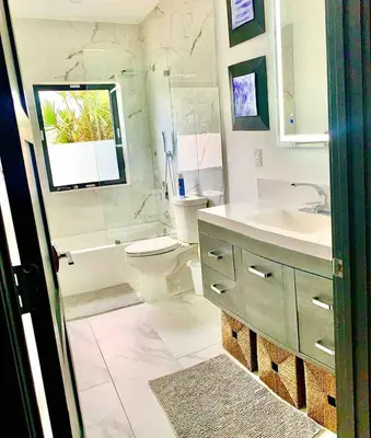 a bathroom with a toilet and a sink and a tub at MIAMi MID-CENTURY GEM in North Miami Beach