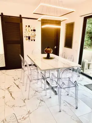 a dining room with a marble table and chairs at MIAMi MID-CENTURY GEM in North Miami Beach