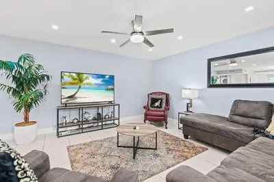 a living room with a couch and a ceiling fan at Beach Pool & Las Olas Getaway Fort Lauderdale in Fort Lauderdale